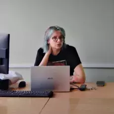 dr Marta Tymińska siedząca przy komputerze prezentująca treści z wykładu